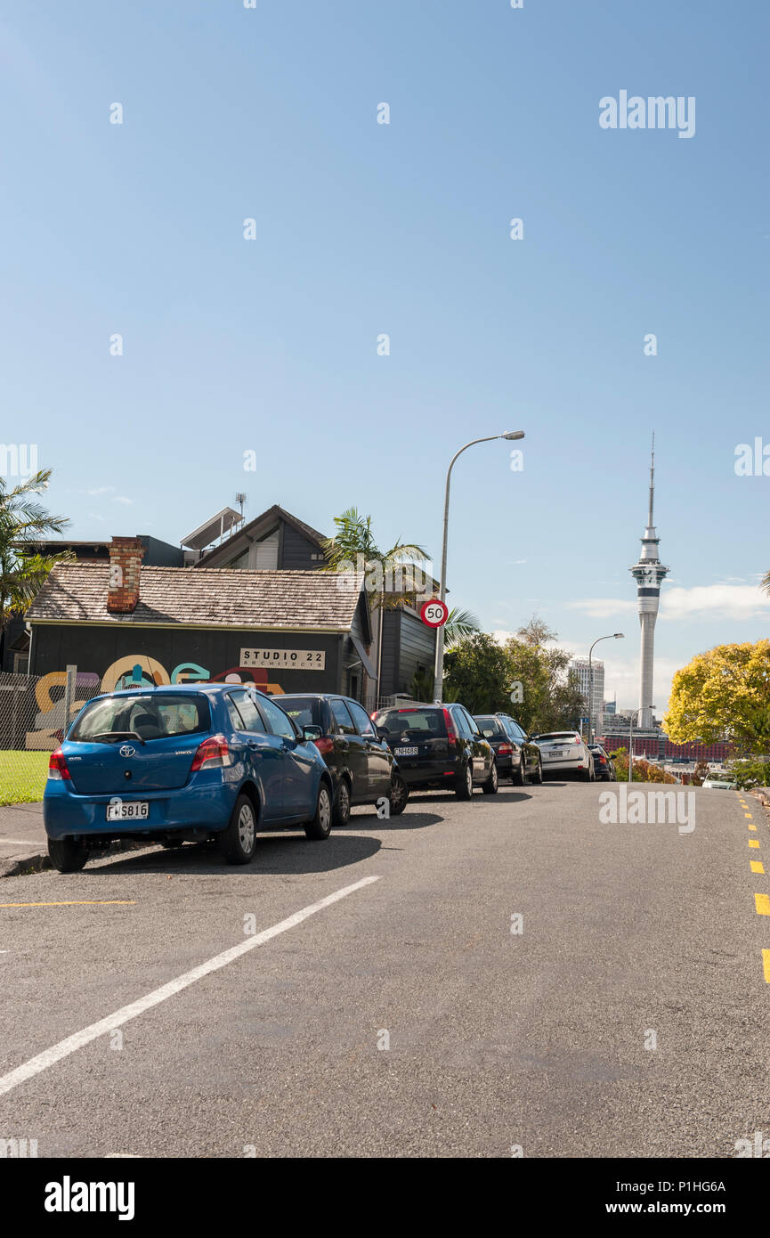 Rue de banlieue dans la région de Ponsonby avec voitures garées et Auckland Sky Tower en arrière-plan de la capitale de la Nouvelle-Zélande Banque D'Images