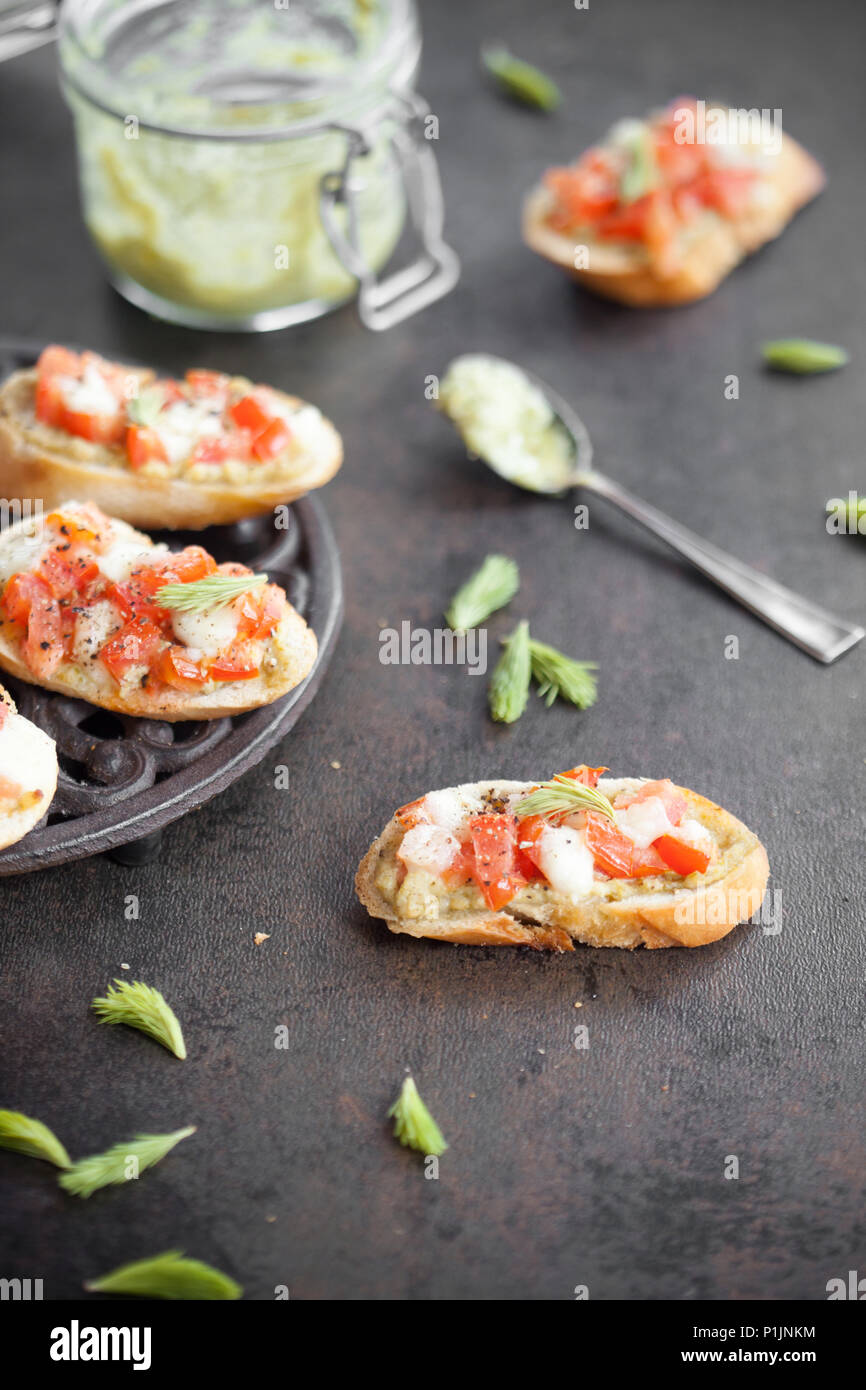 Bruschetta italienne avec pesto de pousses d'épinette, tomates et mozzarella Banque D'Images