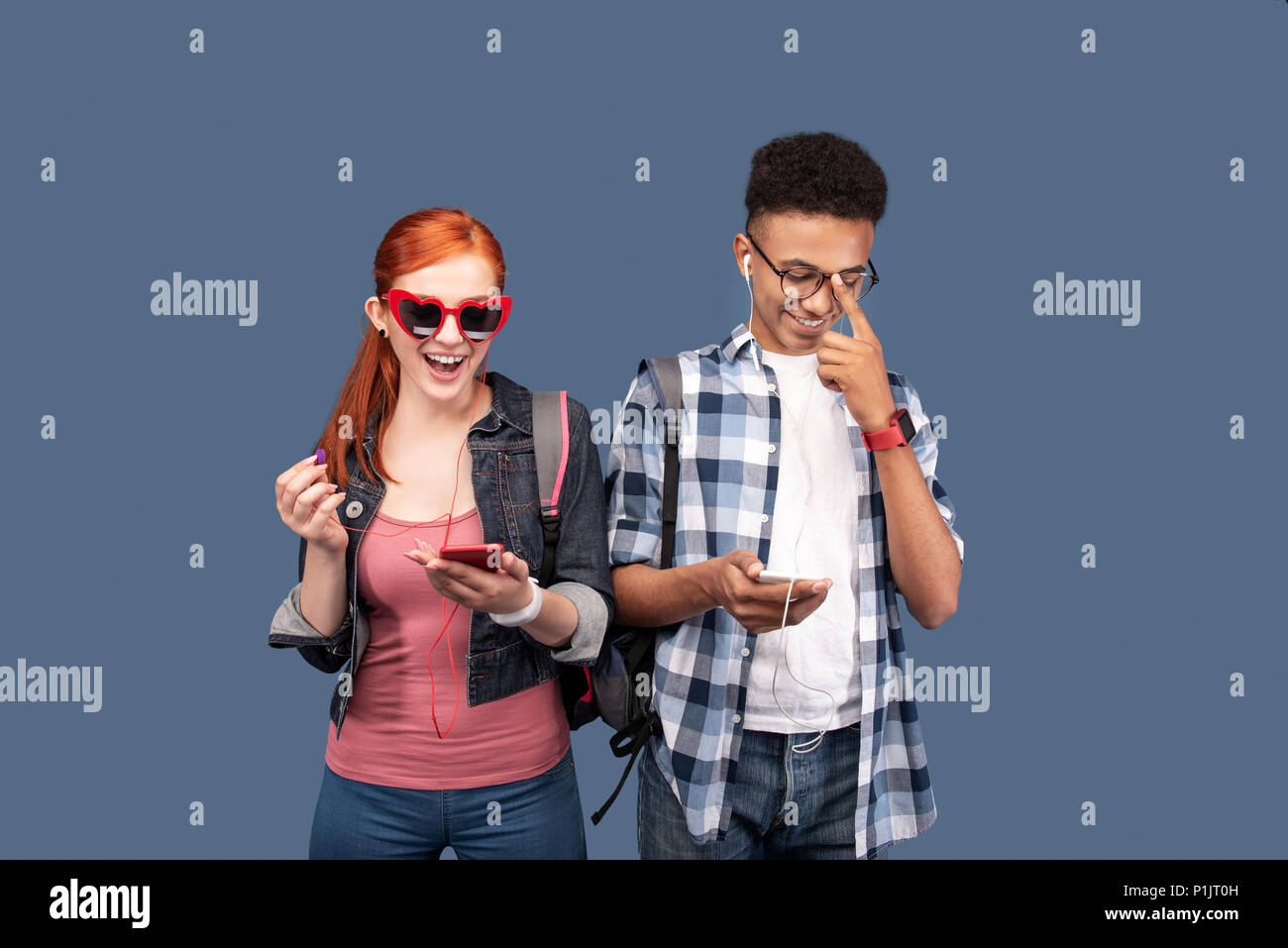 Beau jeune homme fixant ses lunettes Banque D'Images
