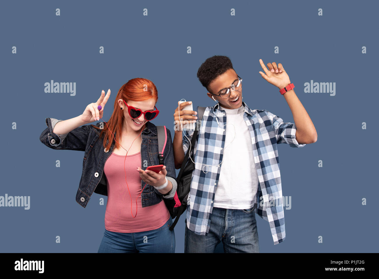 Les gens joyeux positif portant des écouteurs Banque D'Images