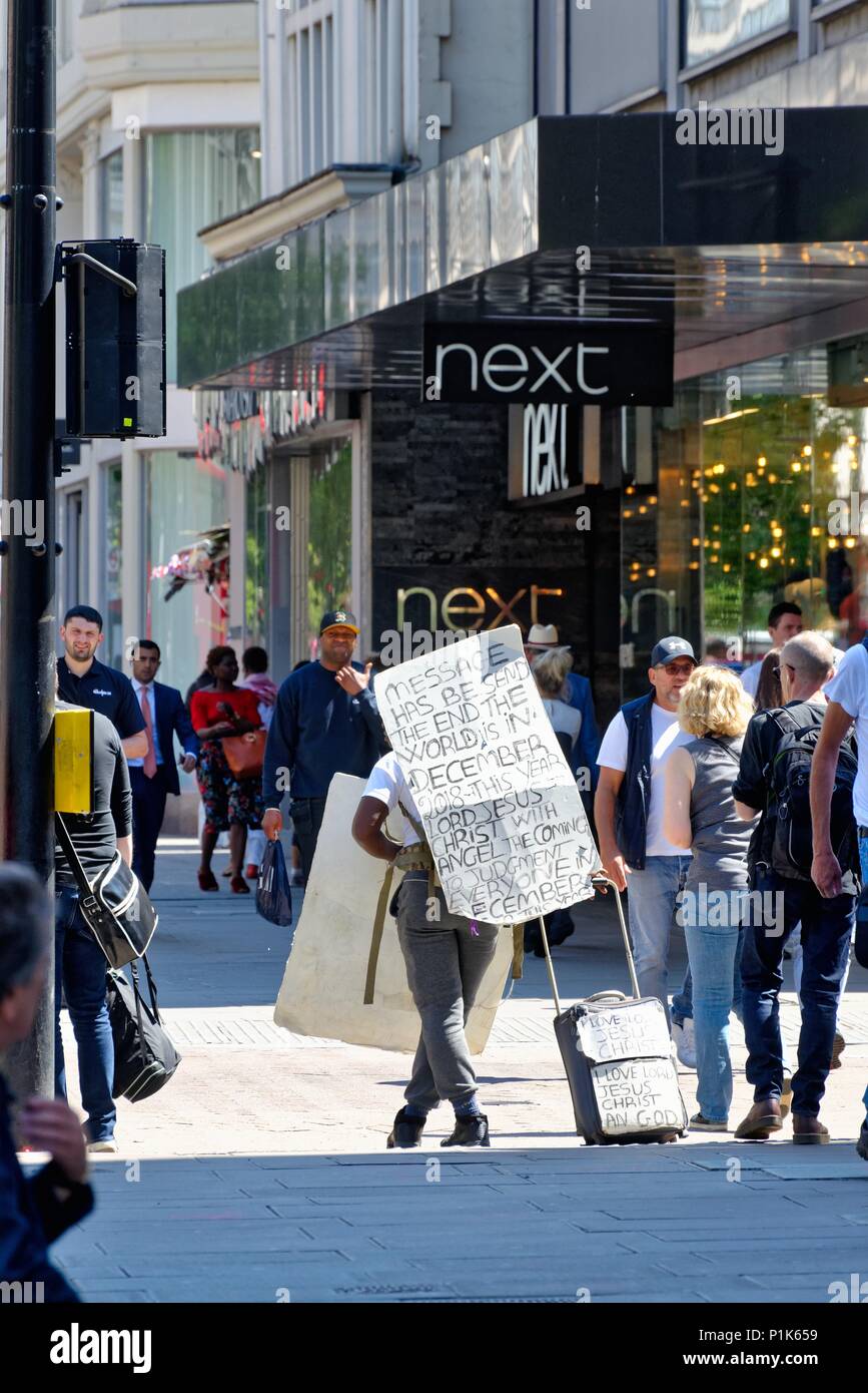 Un homme marche sur Oxford Street, au centre de Londres avec un signe sur son dos annonçant la fin du monde approche, England UK Banque D'Images