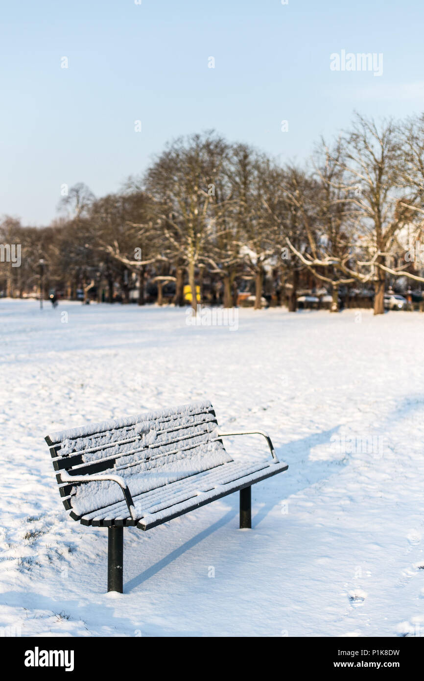 Banc couvert de neige dans le parc, Londres, Angleterre, Royaume-Uni Banque D'Images