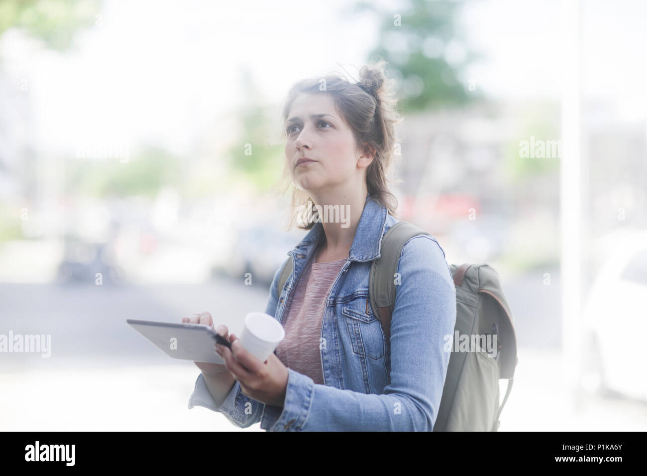 Femme debout dans la rue à l'aide d'une tablette numérique Banque D'Images