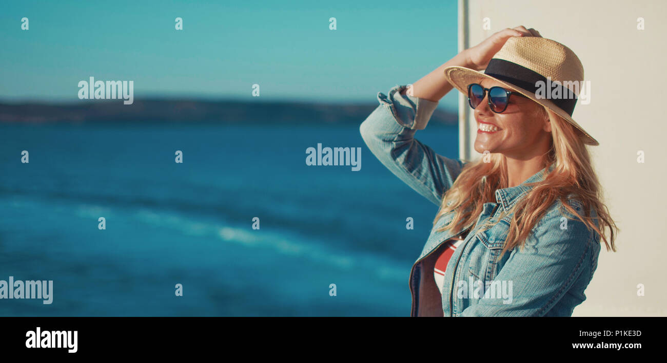 Happy young blonde woman traveler posing on cruise ship deck banner Banque D'Images