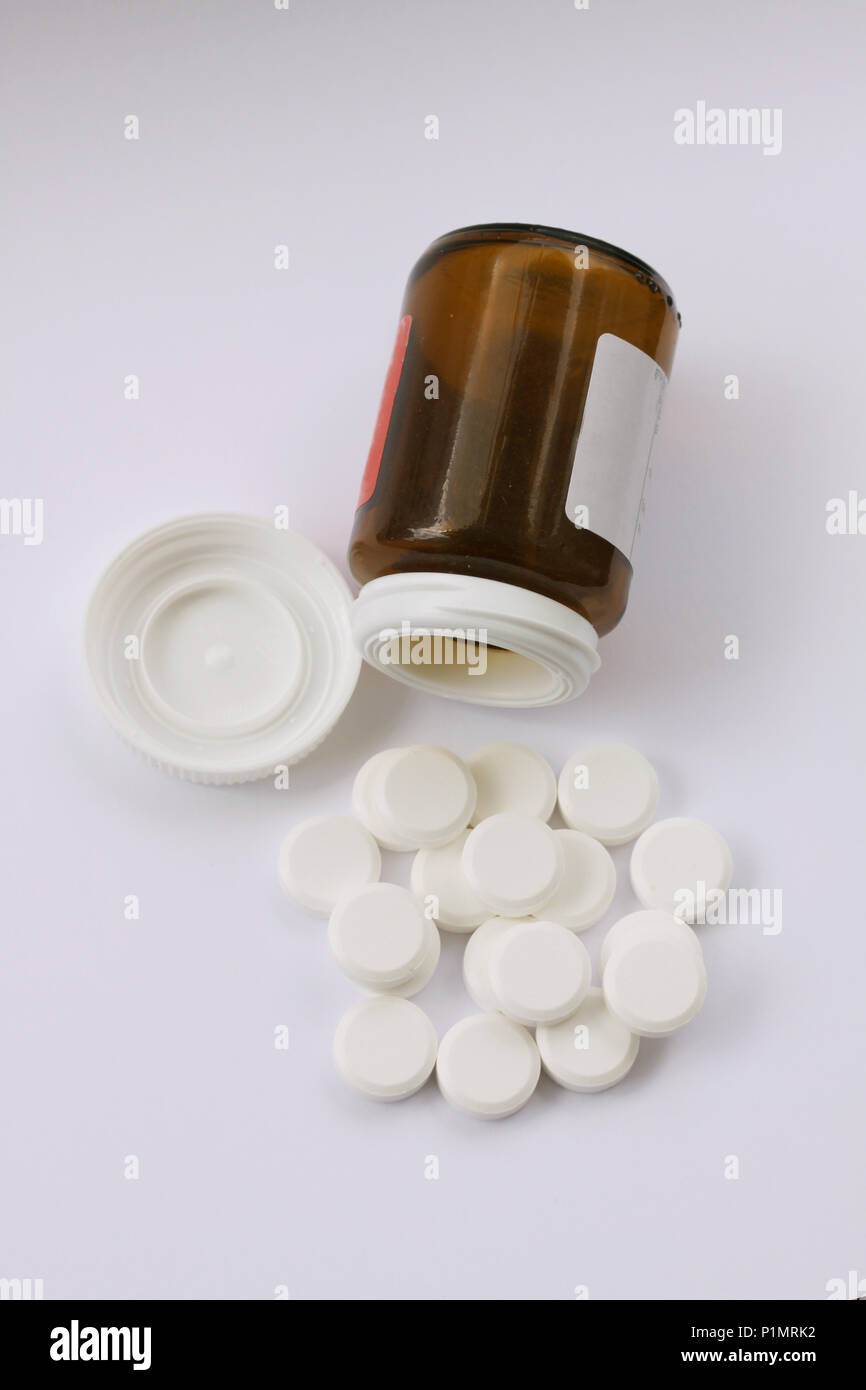 Comprimés blancs déversés par tombé bouteille de pilules. Vue de dessus de pilules et médicaments contenant couché sur fond blanc illustrant la toxicomanie. Close up Banque D'Images