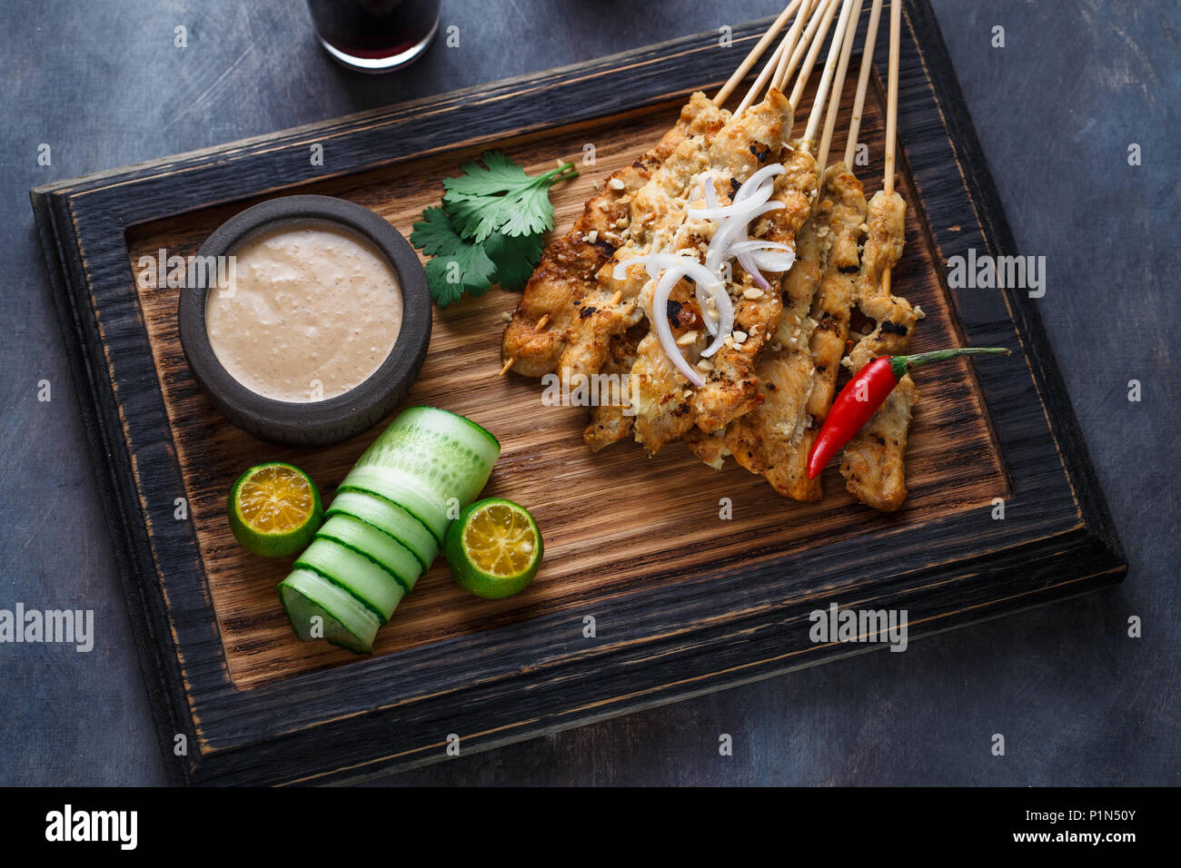 Fermer la vue de malaysian les brochettes de poulet satay ayam sate - ou à l'arachide, un arrière-plan sombre. Banque D'Images