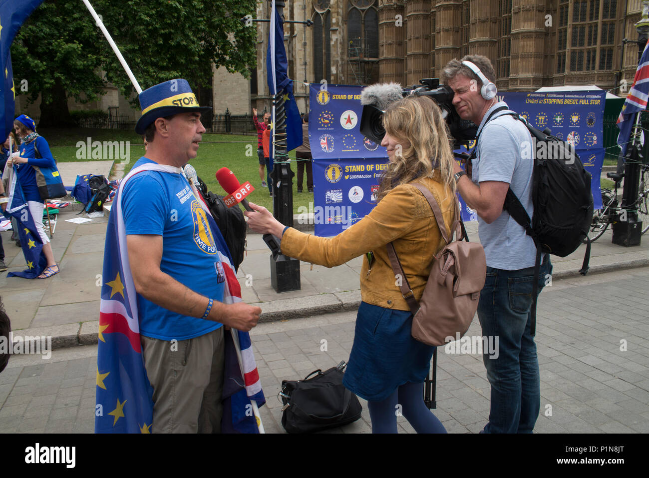 Londres, Royaume-Uni. 12 juin 2018. 12 juin 2018 - Londres : Entretien avec Steve Bray à partir de la chaîne de télévision autrichienne ORF. Les manifestants de brandir le drapeau SODEM (Stand de défi, Mouvement européen) à côté du Parlement et college green. Credit : Bruce Tanner/Alamy Live News Banque D'Images