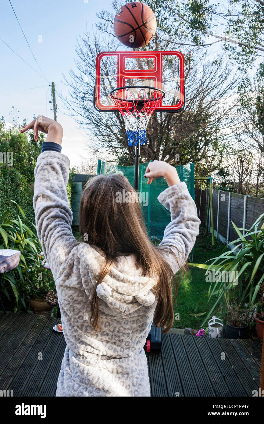 Personne fille, le tournage d'un panier, jouer au basket-ball dans le jardin, en transit, balle balle en l'air, basket ball, Dublin Irlande Banque D'Images