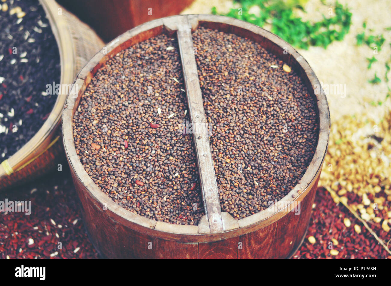 Graines de moutarde, de lin, de tournesol et de coriandre sont déversées à partir de sacs de linge Banque D'Images