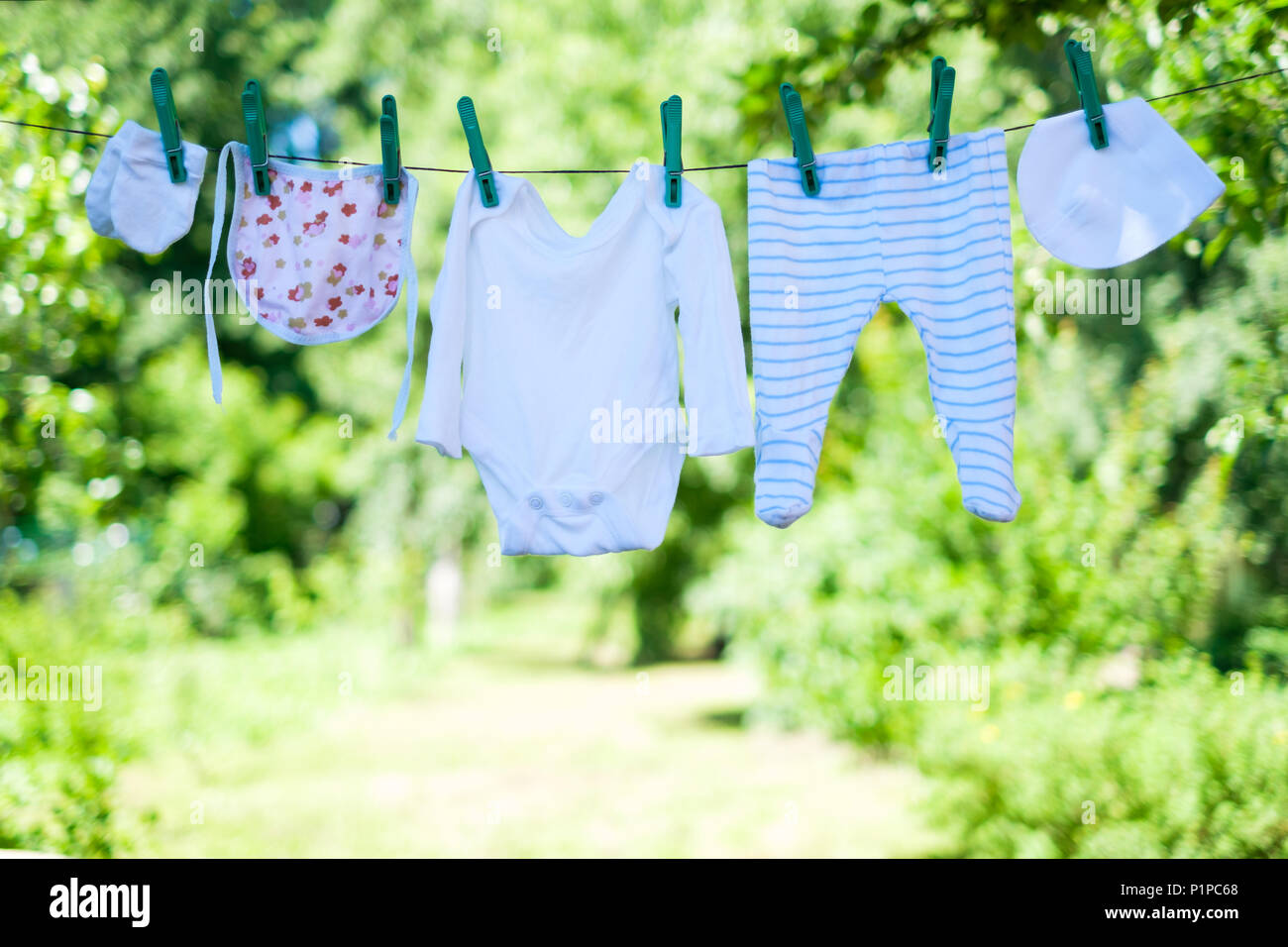 Vêtements de bébé sur corde à linge dans le jardin Banque D'Images