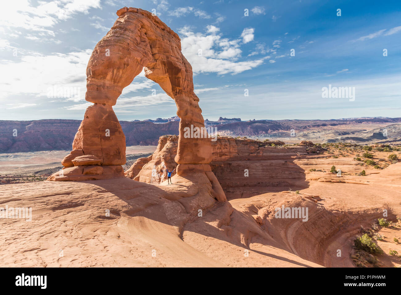 Un female hiker est célèbre sous le Delicate Arch dans Arches National Park, Moab, Utah, États-Unis d'Amérique Banque D'Images