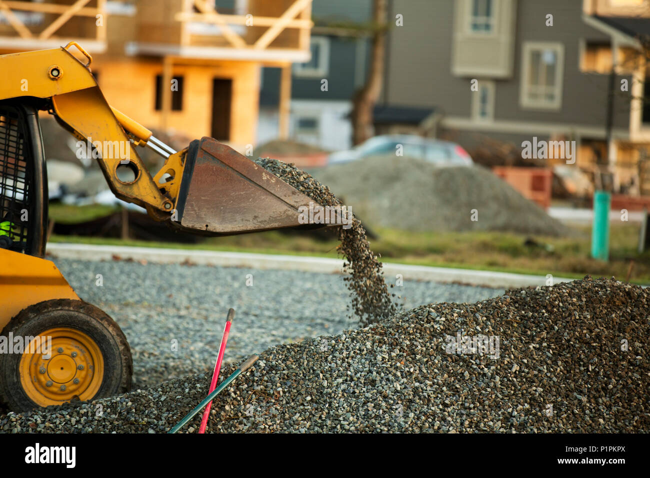 Petit chargeur avant déménagement et plaçant de gravier dans un parc d'une nouvelle construction ; Langley, Colombie-Britannique, Canada Banque D'Images