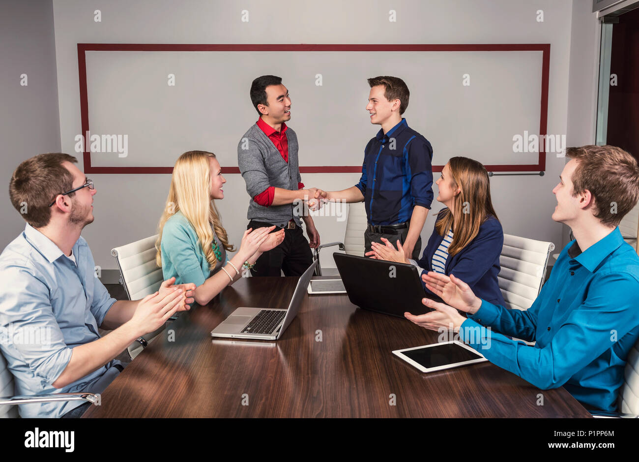 Les jeunes entreprises millénaire professionnels qui travaillent ensemble dans une salle de conférence dans un lieu d'affaires et louer les efforts de l'un de leurs pairs Banque D'Images