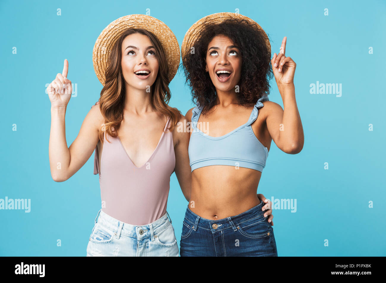 Deux professionnels des jeunes filles habillés en vêtements d'été orientée vers le haut à copie espace isolé sur fond bleu Banque D'Images
