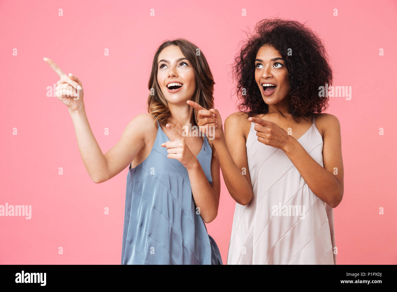 Deux professionnels des jeunes filles habillés en vêtements d'été à l'opposé de l'espace de copie plus isolé sur fond rose Banque D'Images