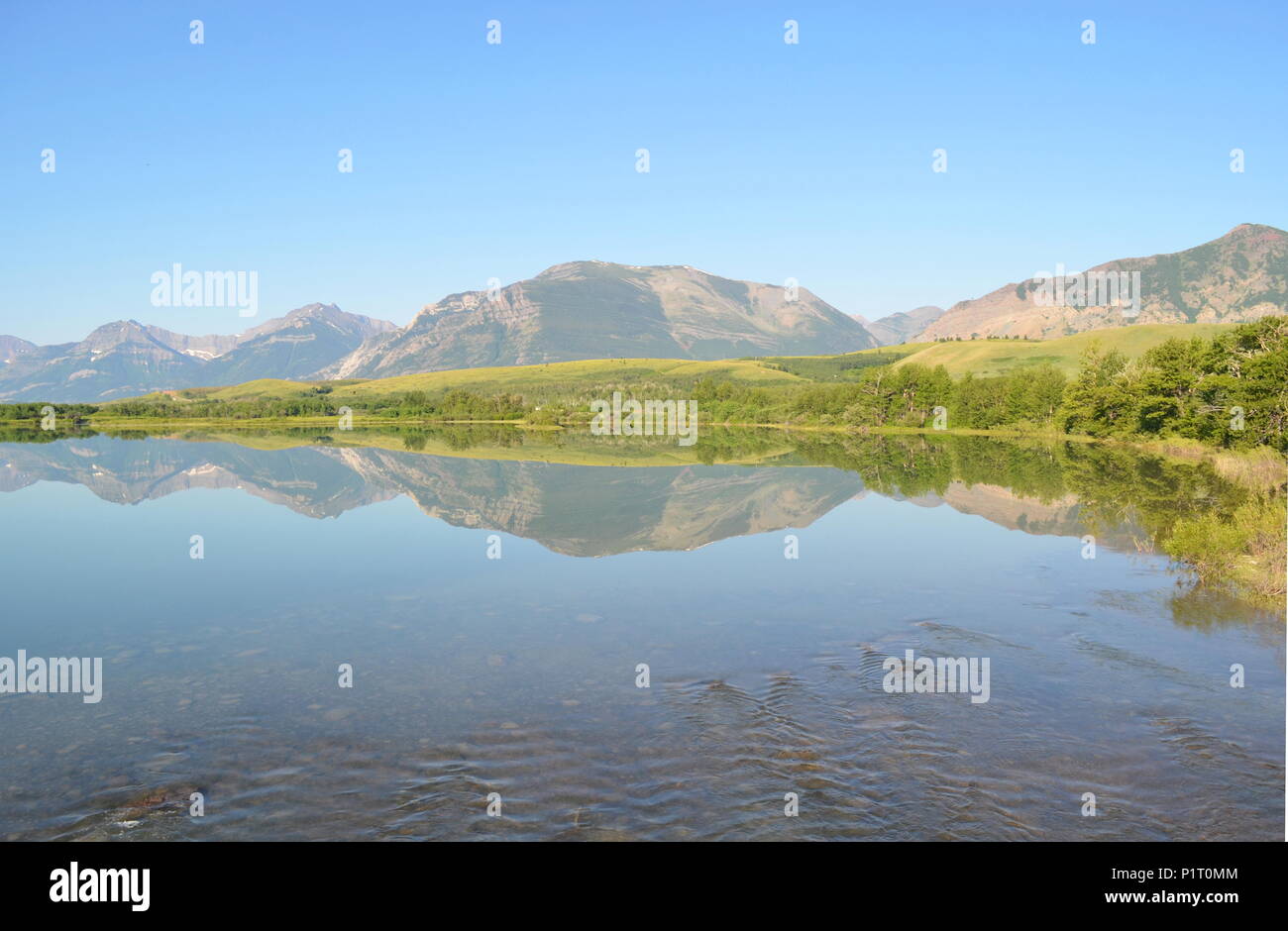 Un lac miroir reflétant les montagnes derrière elle dans le lac Waterton Park, Alberta, Canada. Banque D'Images