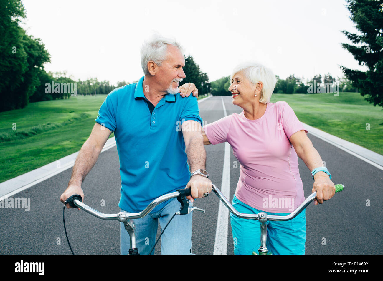 Senior couple allant pour une balade à vélo dans le parc Banque D'Images