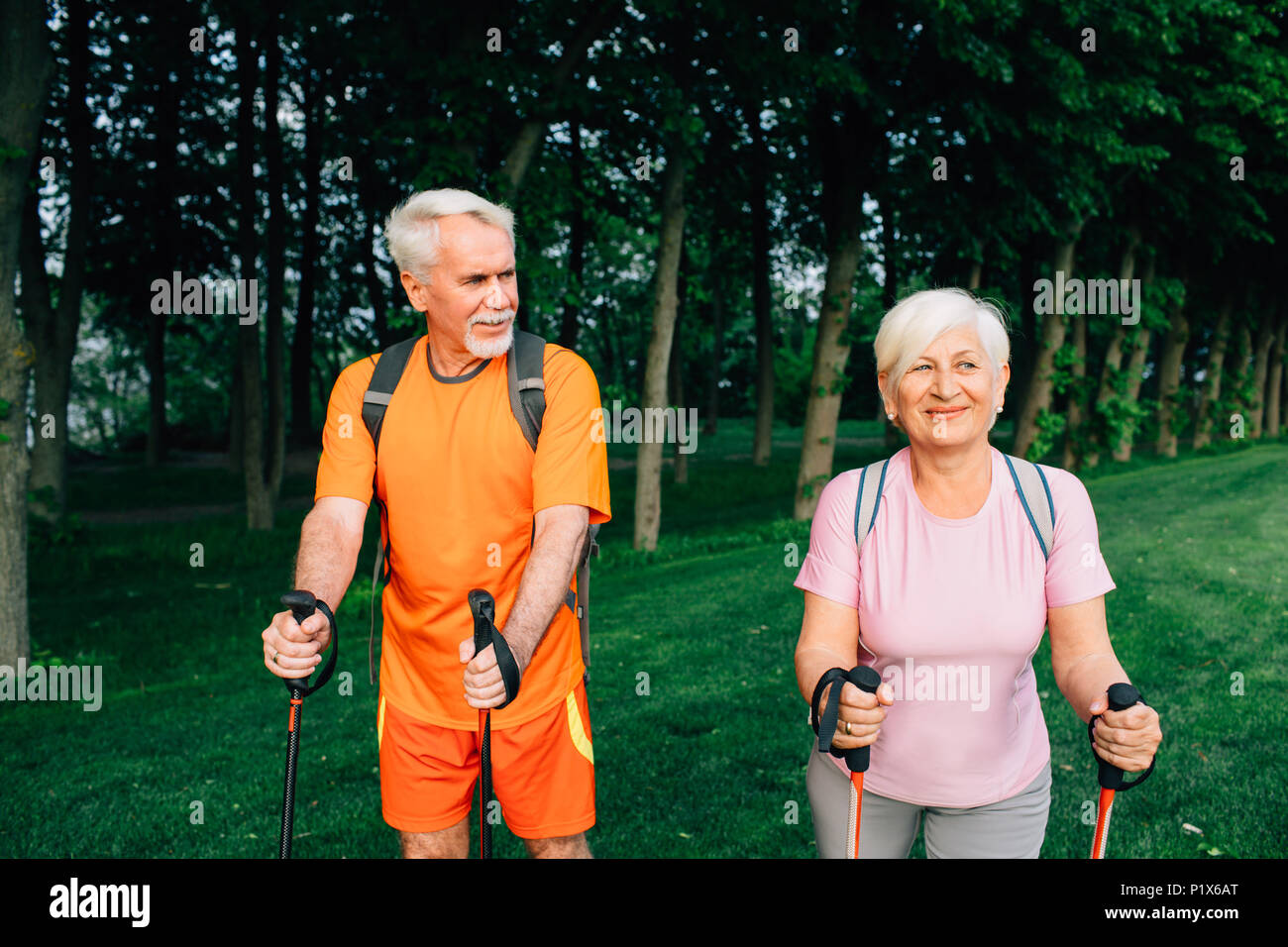 Senior couple hiking ci-dessous d'arbres, d'un mode de vie actif Banque D'Images