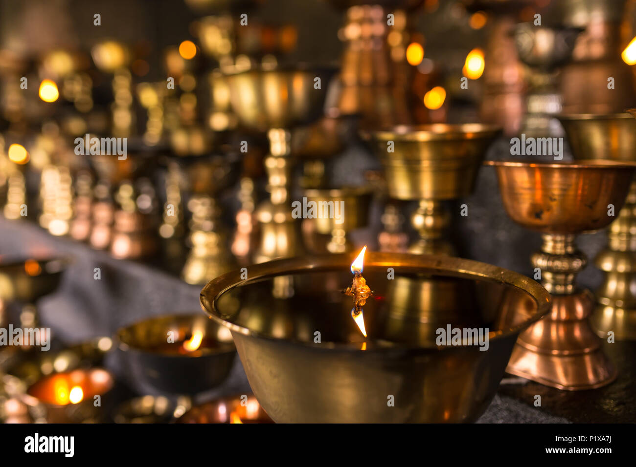 Rituel bouddhiste tibétain bougies huile close-up dans le monastère au Ladakh, Inde Banque D'Images