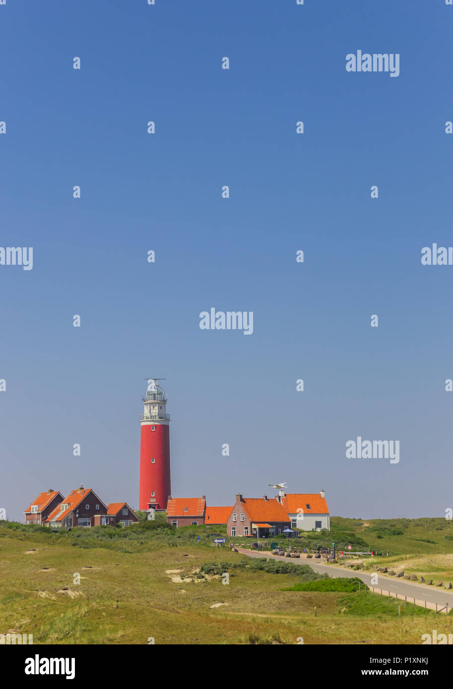 Phare rouge et les maisons dans les dunes de l'île de Texel, Pays-Bas Banque D'Images