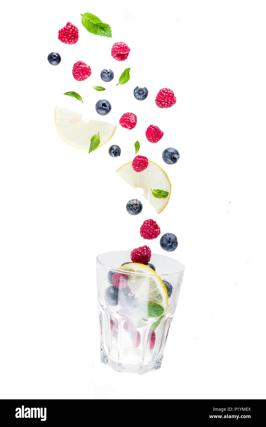 Mise en page créative, l'arrière-plan, avec les baies fraîches, schéma simple sur fond blanc. Framboise, bleuet, feuilles de menthe, des tranches de citron. Concept d'un Banque D'Images