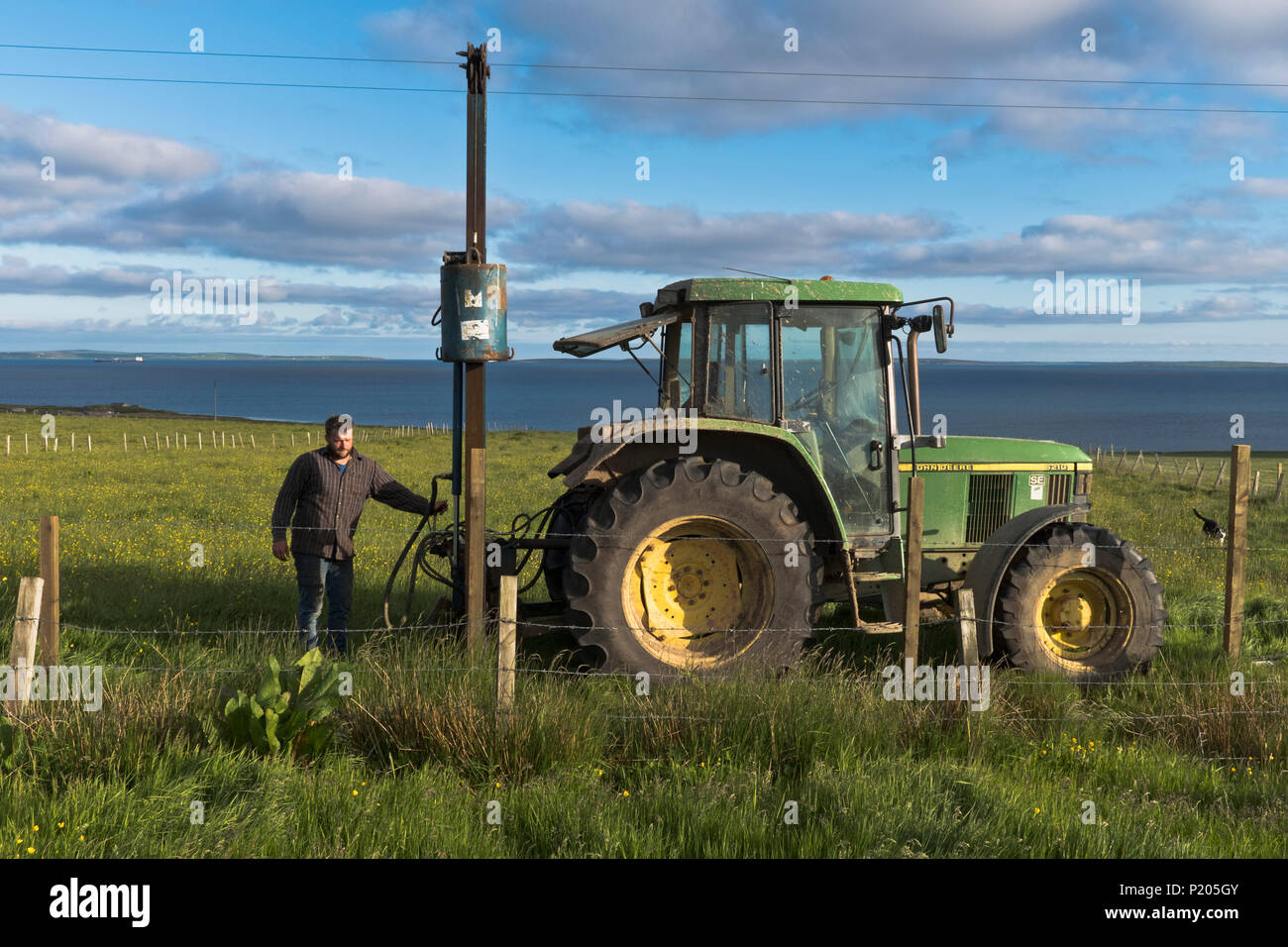 dh Posts clôture ramming machine FARMING Royaume-Uni tracteur champ ramming machines Farmer exploitation poteau rammer barbwire clôture hydraulique RAM personnes Banque D'Images