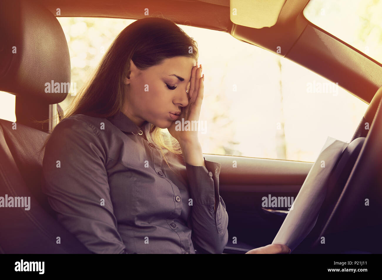 Femme a souligné avec papiers conducteur assis à l'intérieur de sa voiture Banque D'Images