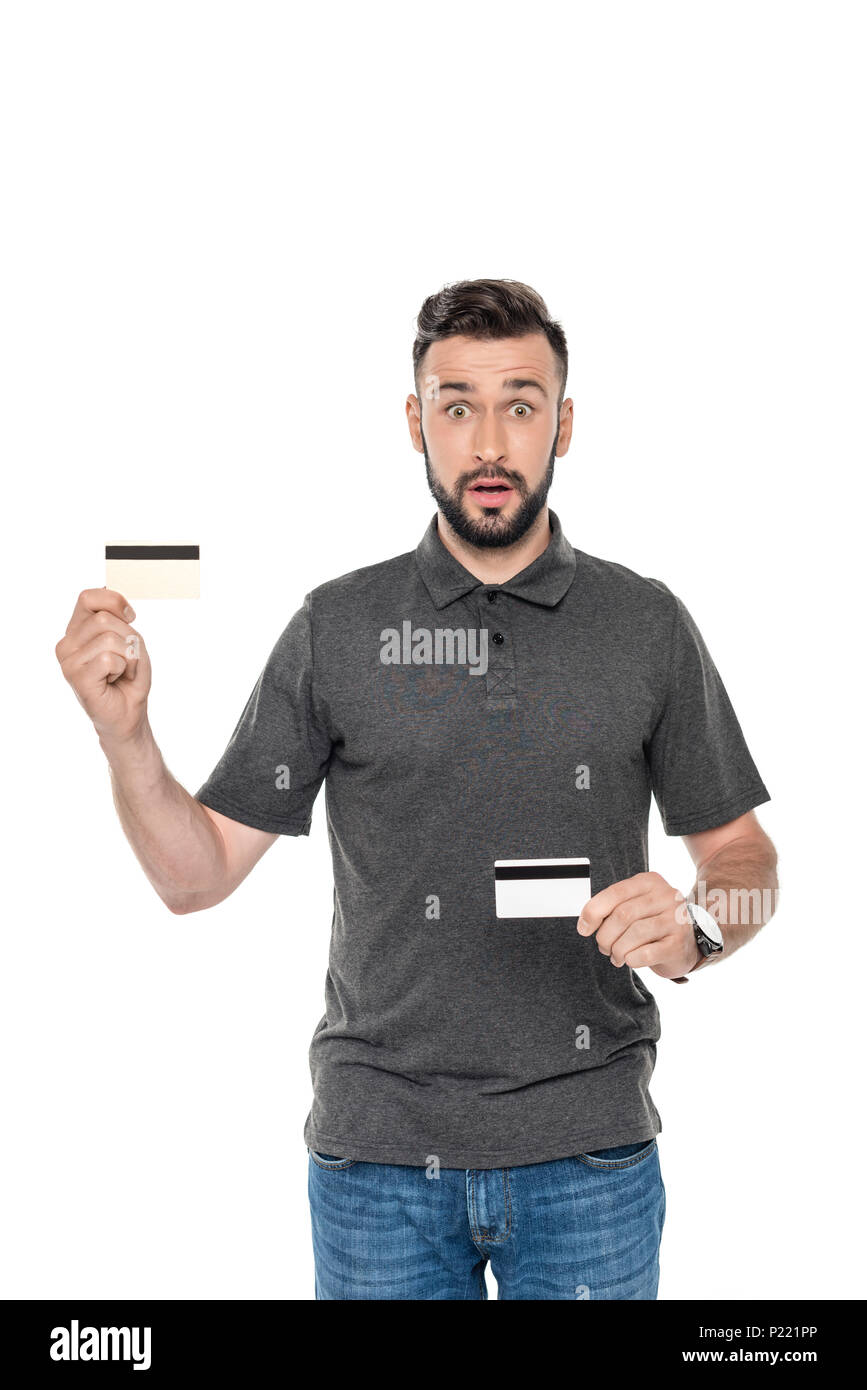Portrait d'homme choqué montrant des cartes de crédit en mains isolated on white Banque D'Images