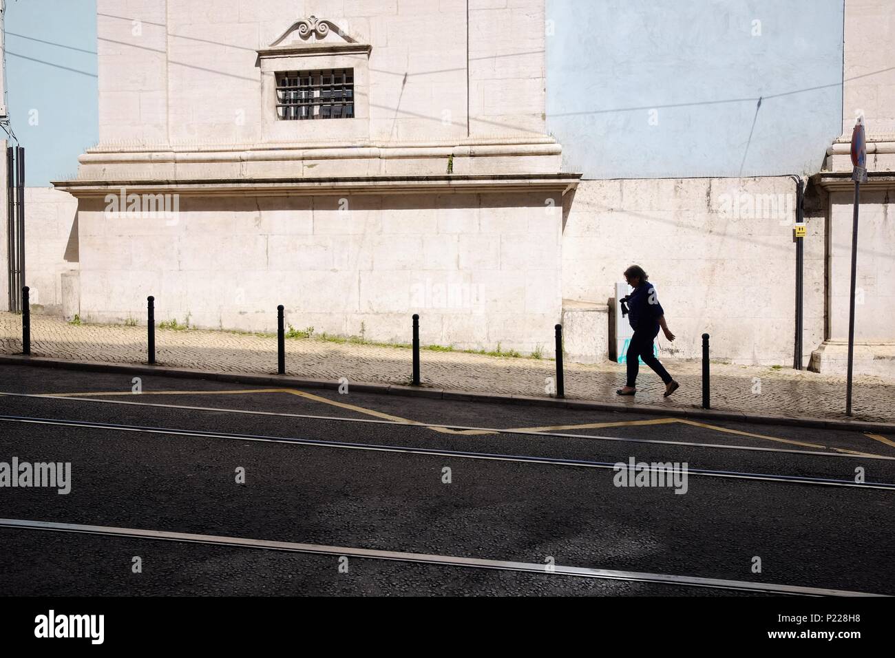 Silhouette femme marche passé bleu poudre vieux mur Banque D'Images