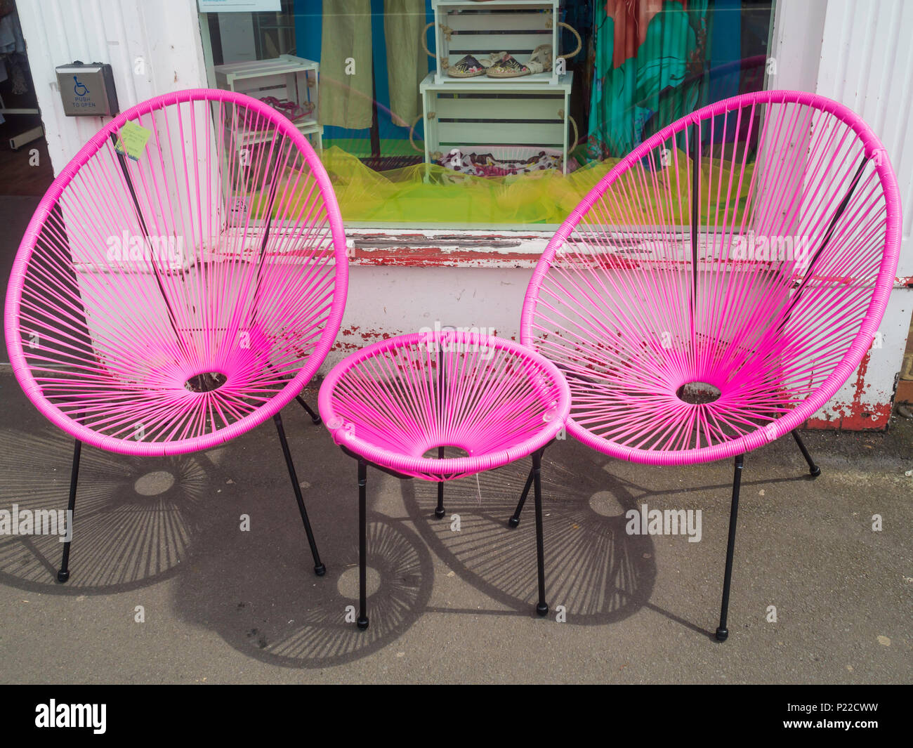 Style années 60, string style Ensemble Bistro chaises avec bâti en métal et plastique rose matériau étiré coin magasin de charité vente Banque D'Images