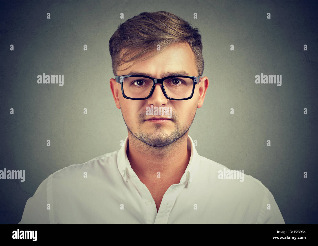 Gros plan du jeune homme en chemise blanche et lunettes noires à la caméra à sérieusement être professionnel. Banque D'Images