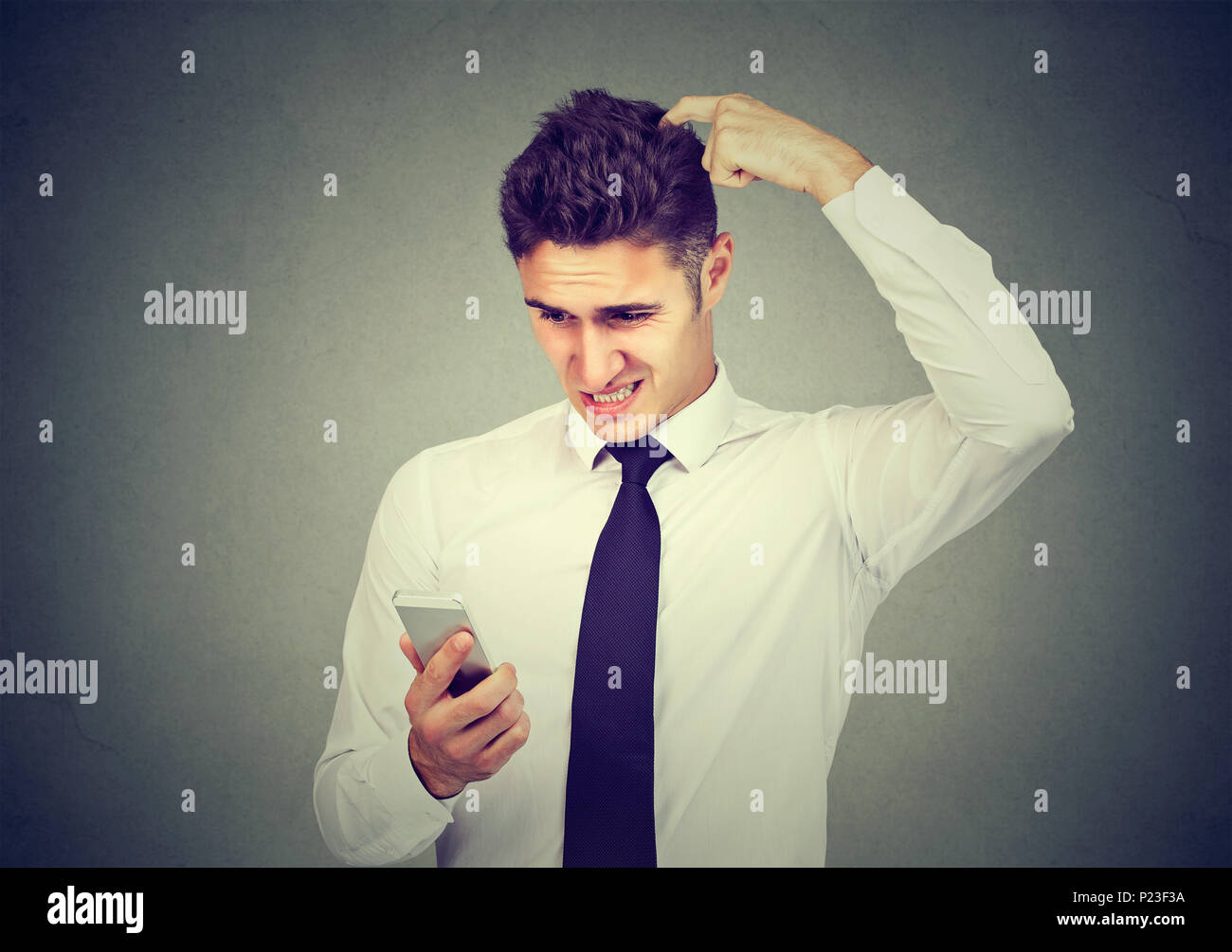 Clueless confondu l'homme d'affaires ayant des problèmes avec son smartphone. Technologie concept compliqué Banque D'Images
