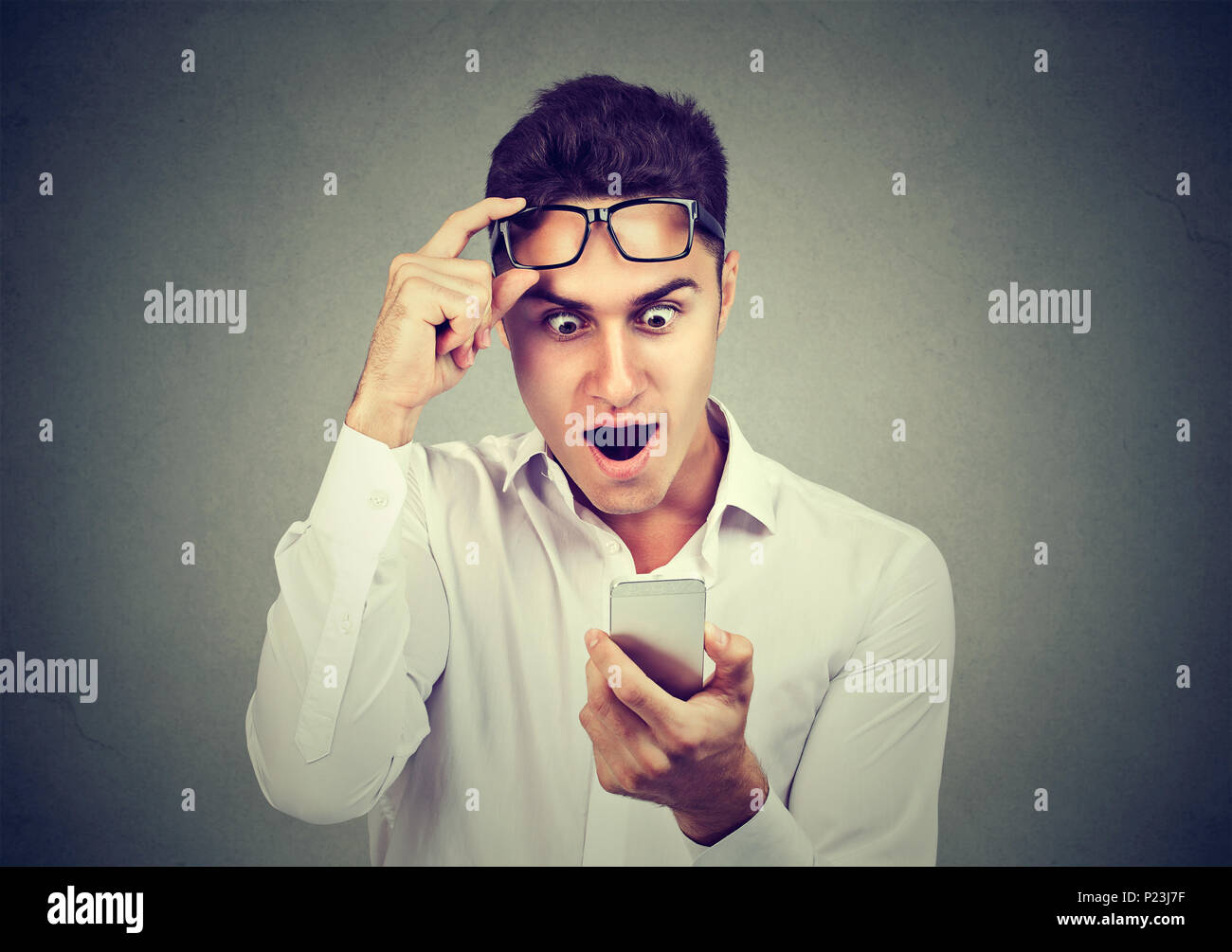 Homme choqué à la lecture de nouvelles on smart phone Banque D'Images