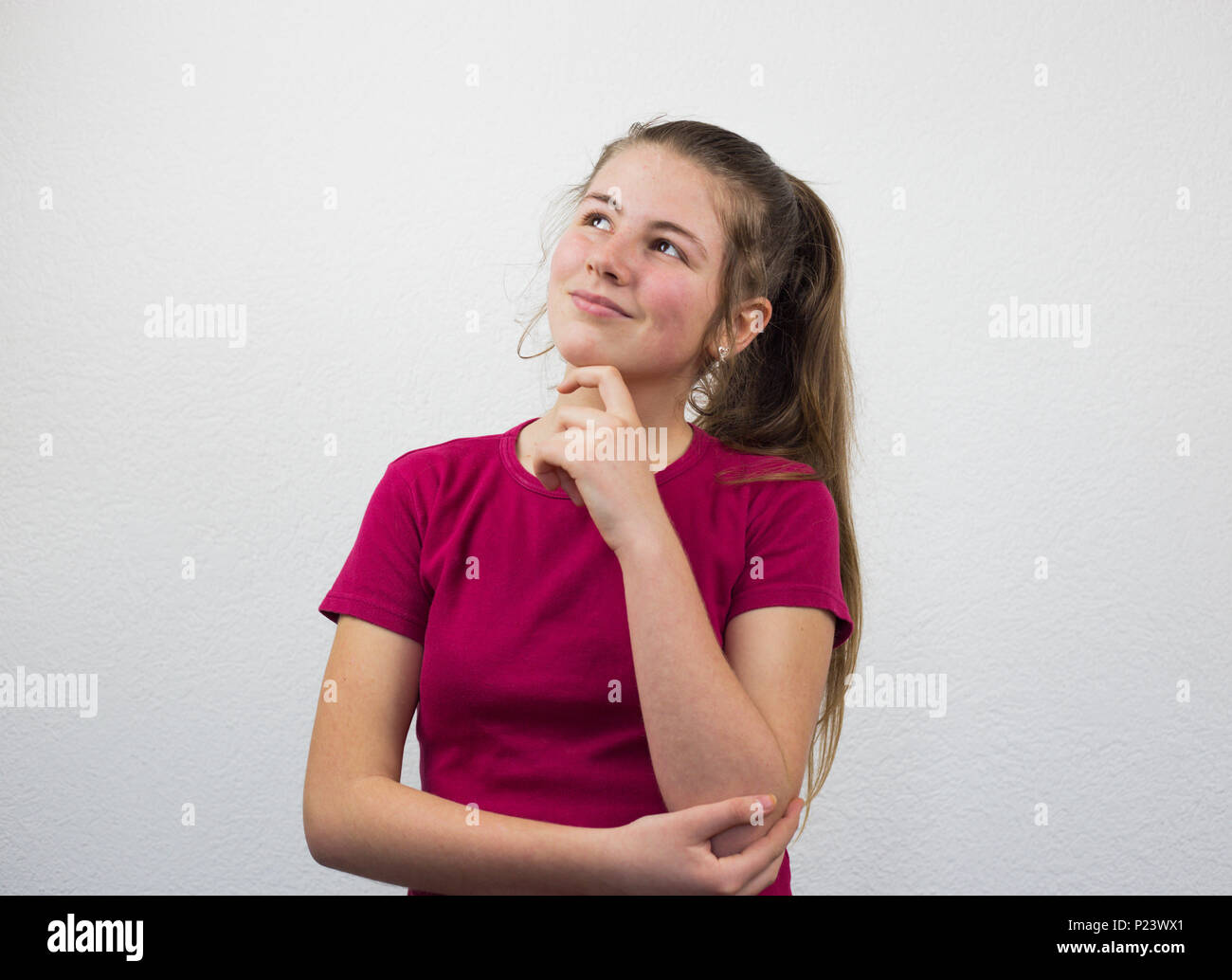 Adolescent est imaginaire en pensées, visage expression, fond blanc Banque D'Images