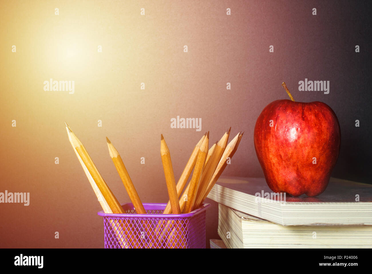 Red Apple sur livre avec tableau noir et craie crayon (conseil) comme arrière-plan avec la lumière. L'éducation est un pouvoir concept. Banque D'Images