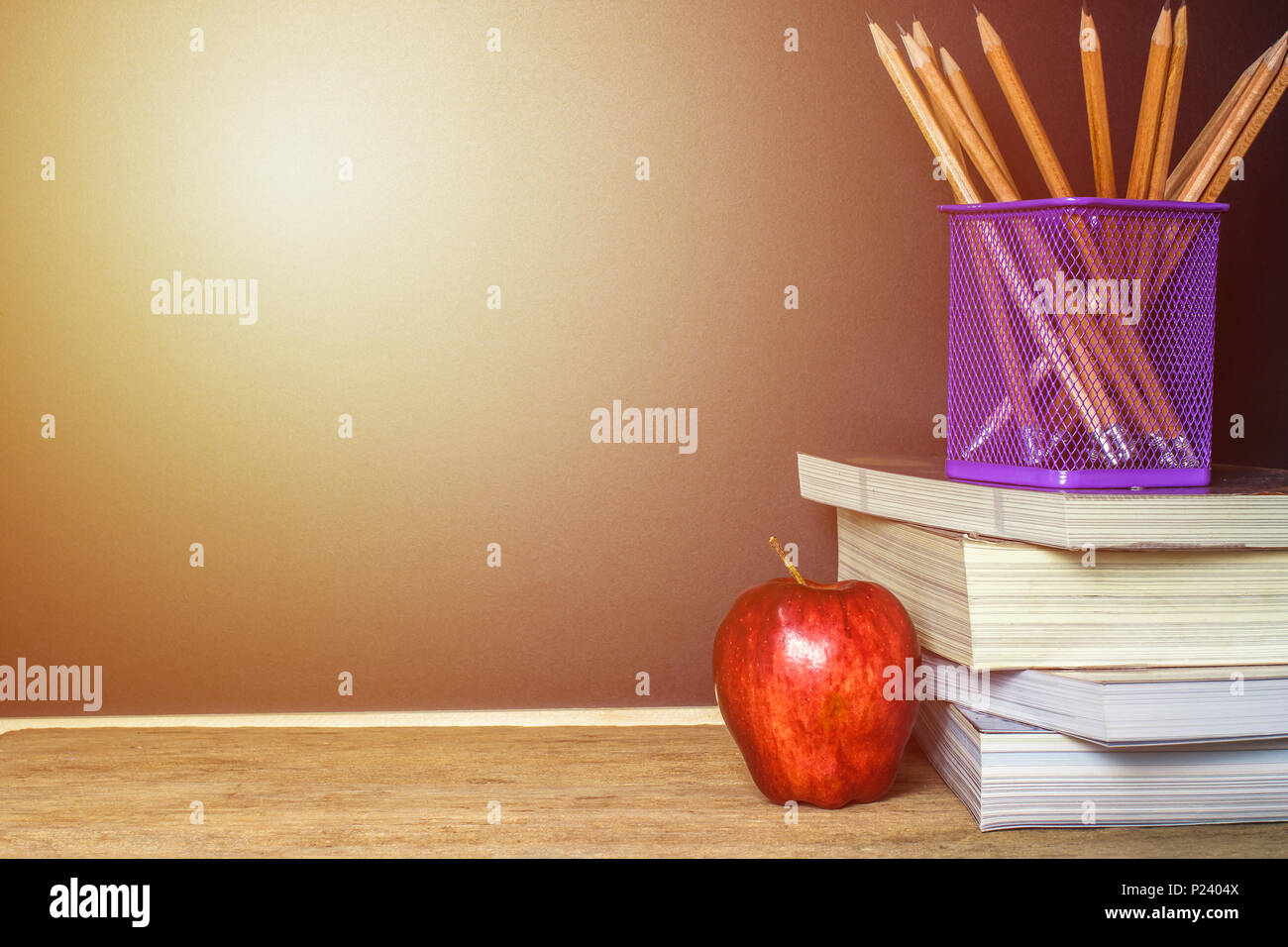 Red Apple sur livre avec tableau noir et craie crayon (conseil) comme arrière-plan avec la lumière. L'éducation est un pouvoir concept. Banque D'Images