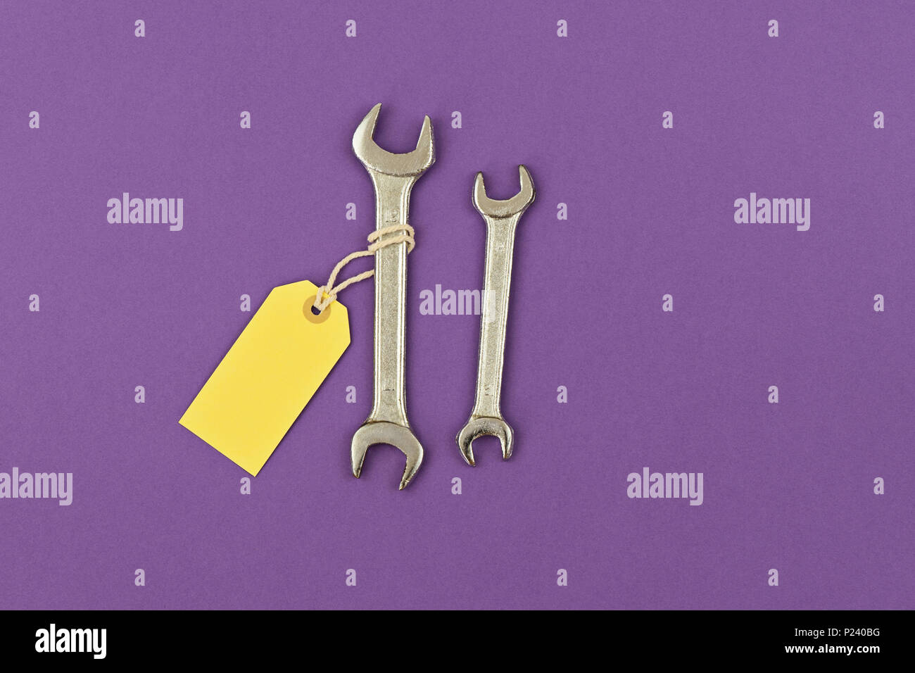 Deux clés pour grands et petits avec étiquette de prix jaune fond violet. Carte de souhaits pour souligner la fête des Pères, la vente concept, copy space Banque D'Images