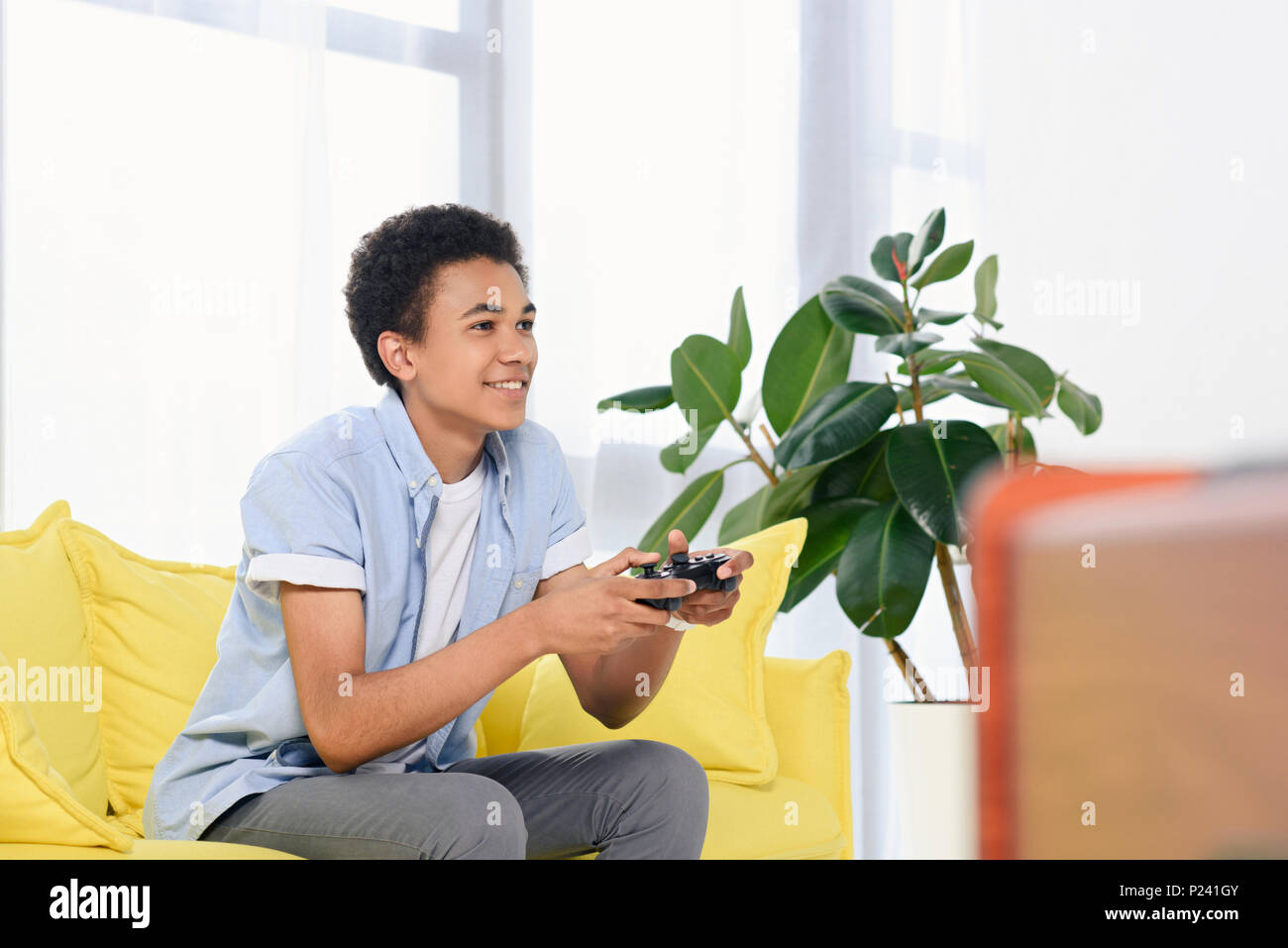 African American teenager playing video game at home Banque D'Images