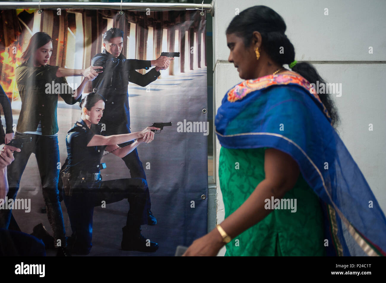 Singapour, République de Singapour, une femme passe une affiche publicitaire Banque D'Images