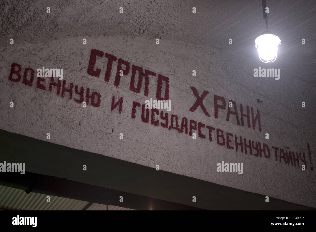 Sur un mur en béton peinture a écrit un slogan, avec l'ampoule suspendue Banque D'Images