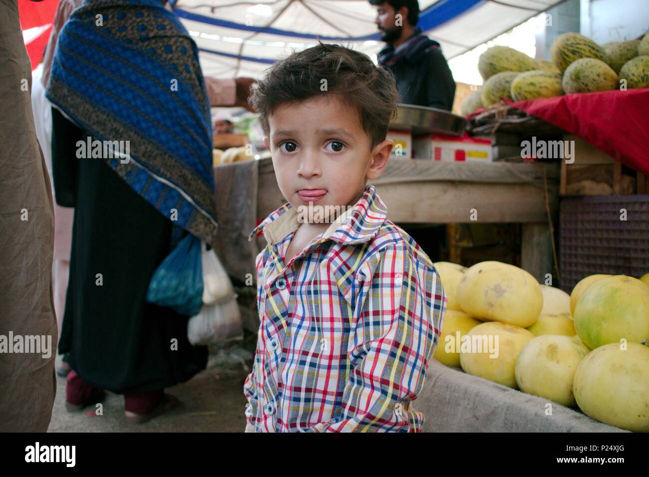 Belle cute kid (enfant) avec sa langue, et de grands yeux ouvert à Islamabad, Pakistan Banque D'Images
