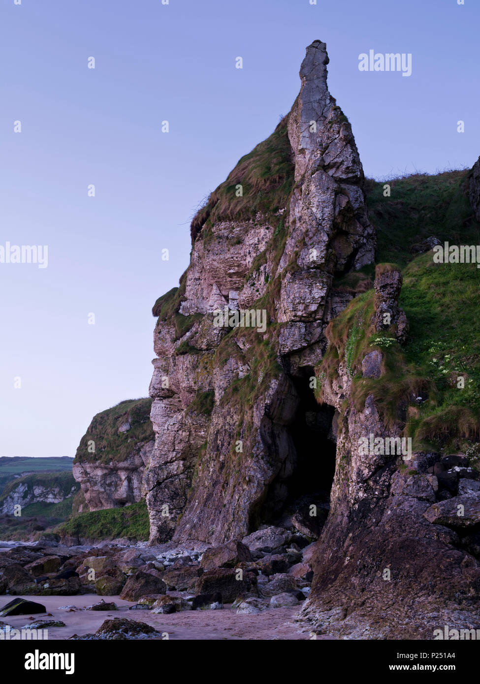 L'Irlande du Nord, d'Antrim, Causeway Coast, côte escarpée fait de calcaire de moules fermer Ballintoy, crag, grotte marine, heure bleue Banque D'Images