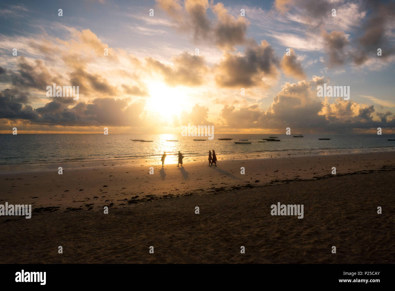 Afrique de l'Est, la Tanzanie, Zanzibar, le lever du soleil sur la plage de Kiwengwa avec un groupe de masai. Banque D'Images Afrique de l'Est, la Tanzanie, Zanzibar, le lever du soleil sur la plage de Kiwengwa avec un groupe de masai. Banque D'Images