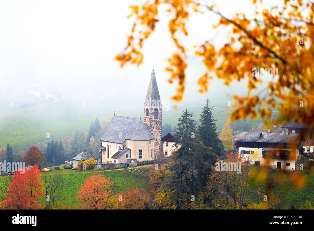 Église de Santa Magdalena dans le brouillard d'automne. Funes Valley, South Tyrol, Dolomites, Italie Banque D'Images