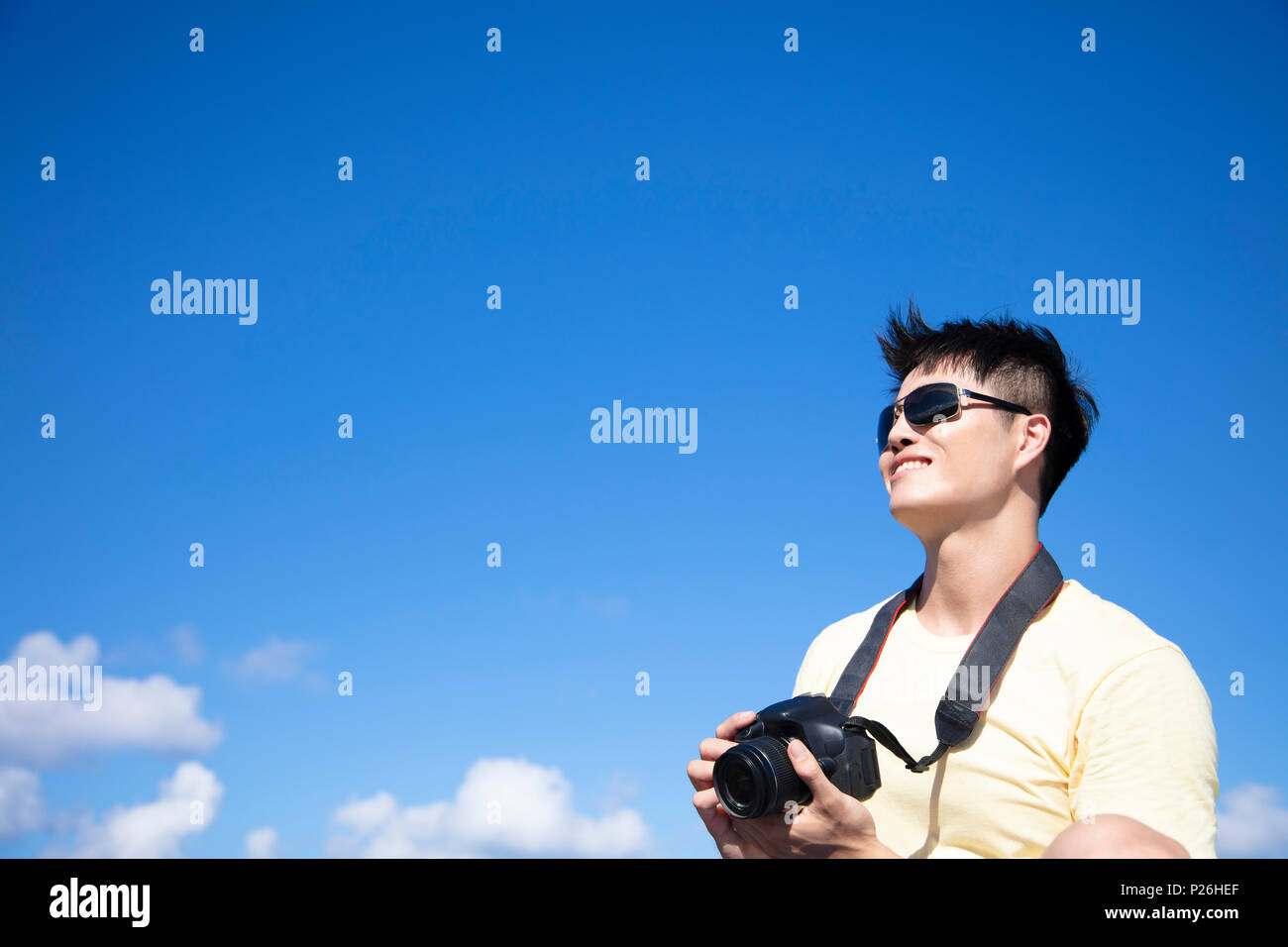 Jeune homme de prendre des photos avec fond de nuage Banque D'Images