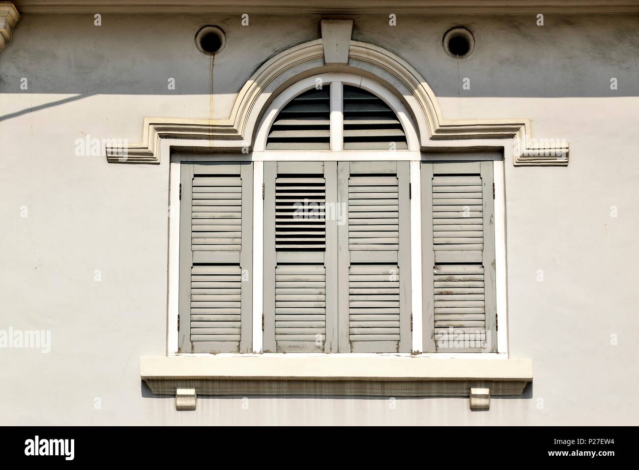 Maison traditionnelle vintage boutique Singapour avec des volets et fenêtre cintrée sur un mur blanc dans le quartier historique de Little India Banque D'Images