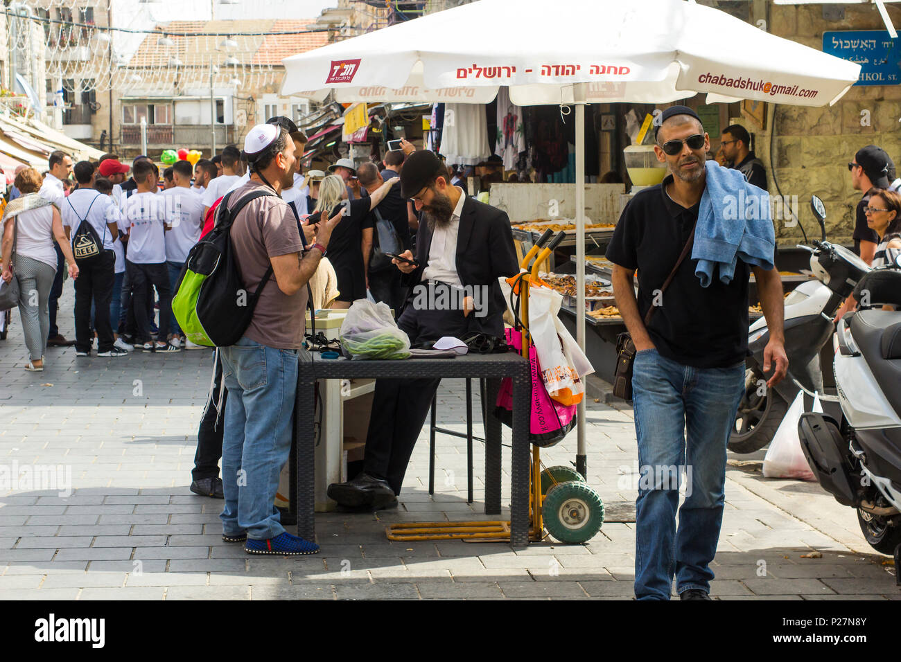 9 mai 2018 un groupe d'hommes juifs à discuter ensemble dans le cadre d'un pare-soleil parasol dans le marché de Mahane Yehuda Street à Jérusalem Israël Banque D'Images
