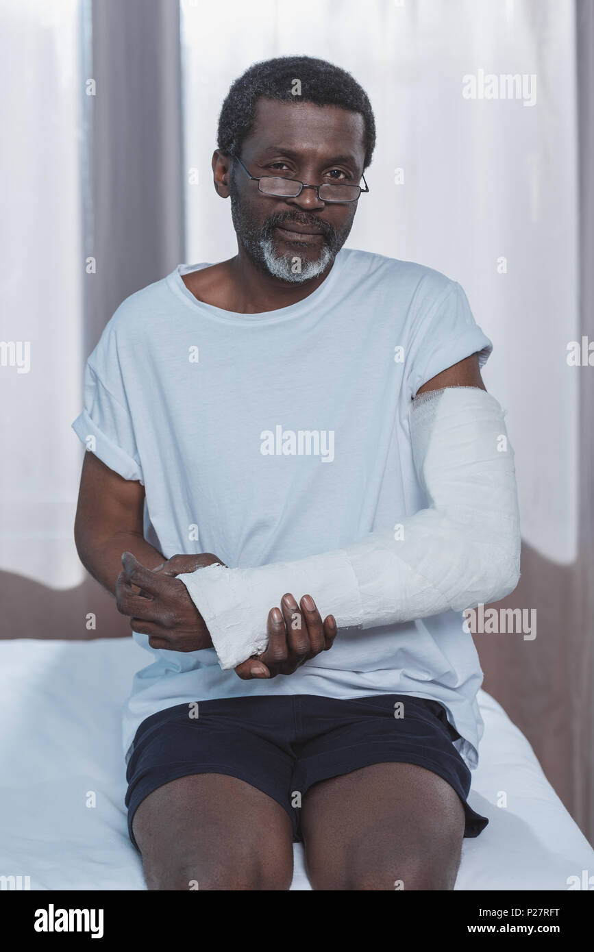 African American patient avec fracture du bras en plâtre Photo Stock