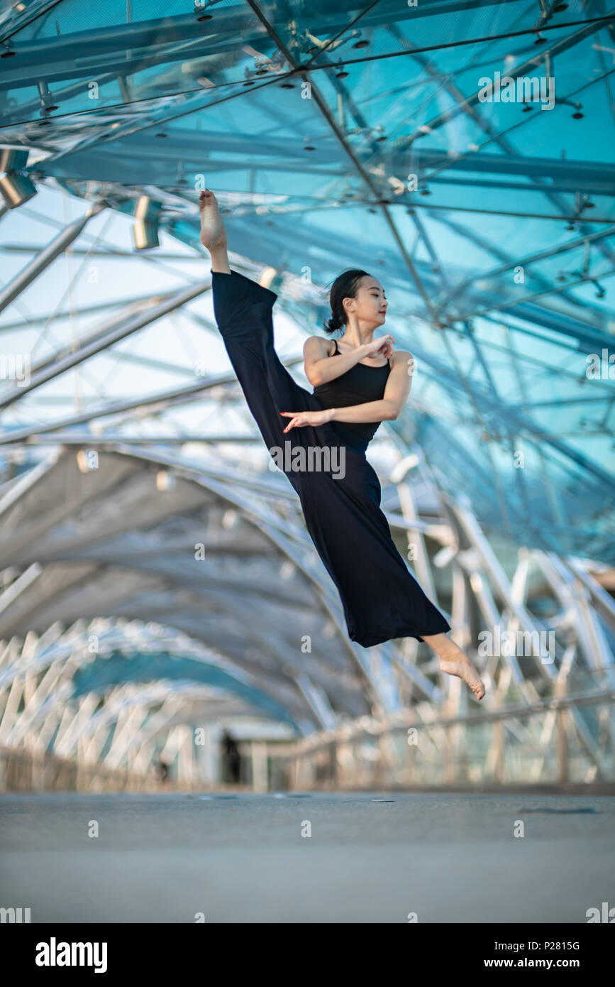 Belle jeune fille dansant sur un pont, vêtu de noir Banque D'Images