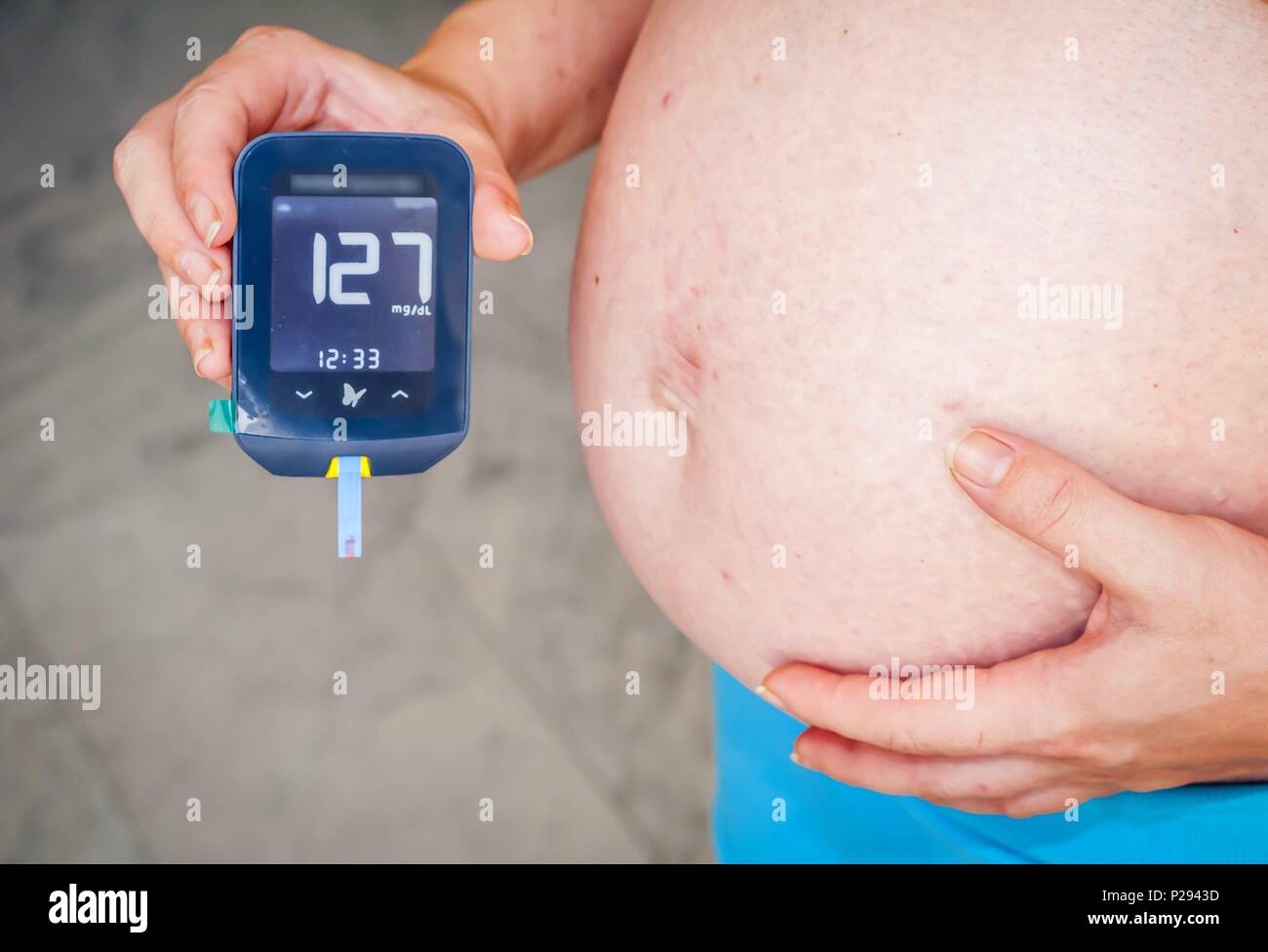 Femme patient avec un diabète de grossesse tenant dans ses mains un glucomètre Freestyle Optium Neo après le test sanguin de glucose avec des résultats. Banque D'Images